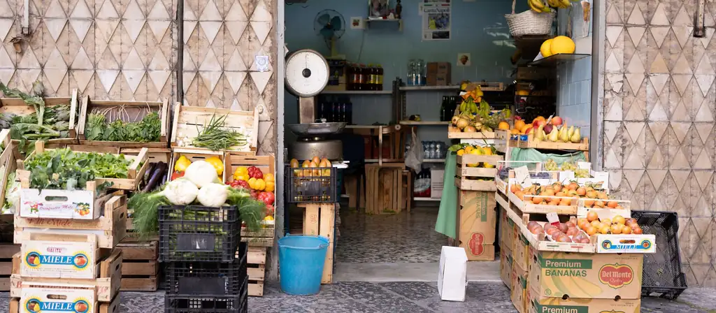 A fruit and vegetable stand stacked with crates of fresh produce